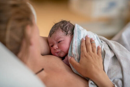 生まれた赤ちゃんを抱く女性