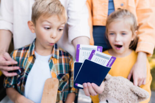 パスポートと航空券をみて驚く男の子と女の子